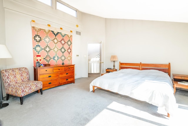 bedroom featuring high vaulted ceiling, carpet, and visible vents