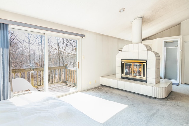 unfurnished bedroom featuring lofted ceiling, access to outside, carpet, and a fireplace