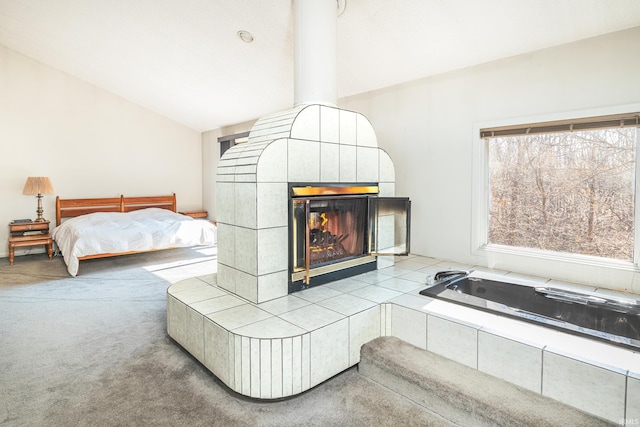 unfurnished bedroom featuring vaulted ceiling, carpet flooring, and a tile fireplace