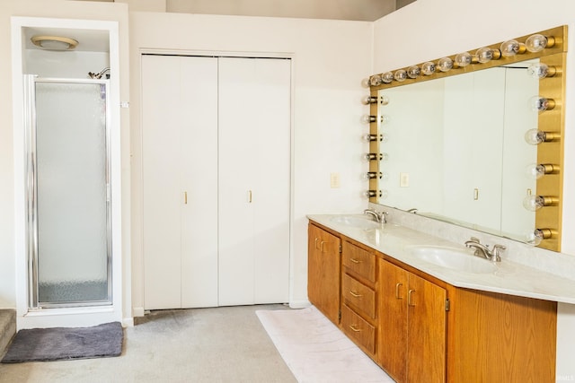 bathroom with a stall shower, a sink, and double vanity