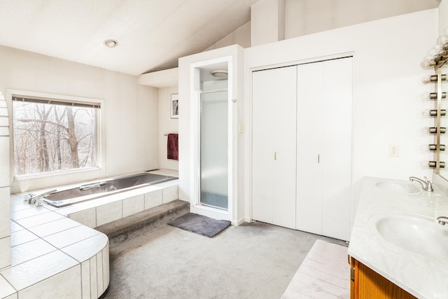 full bath with a garden tub, a shower stall, vaulted ceiling, and a sink