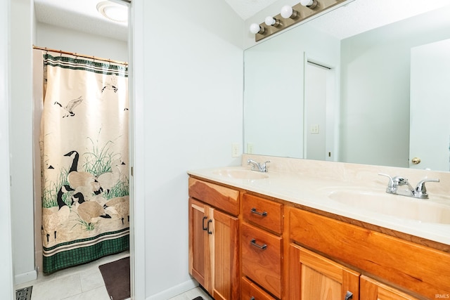 bathroom with double vanity, visible vents, a sink, and tile patterned floors