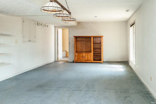 spare room featuring baseboards and a textured ceiling