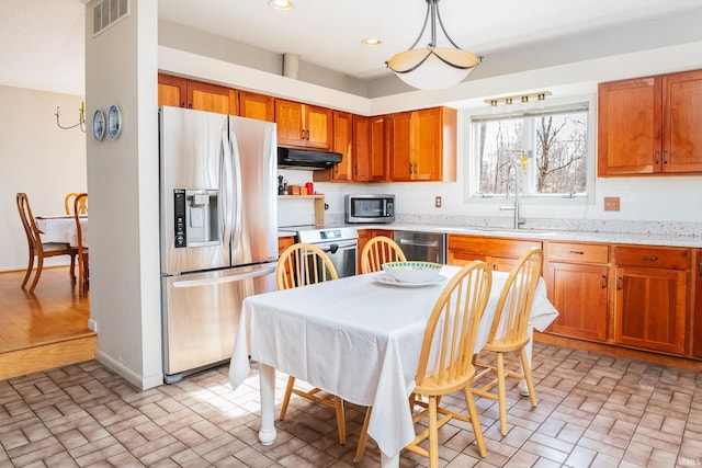 kitchen featuring stainless steel appliances, recessed lighting, visible vents, a sink, and under cabinet range hood