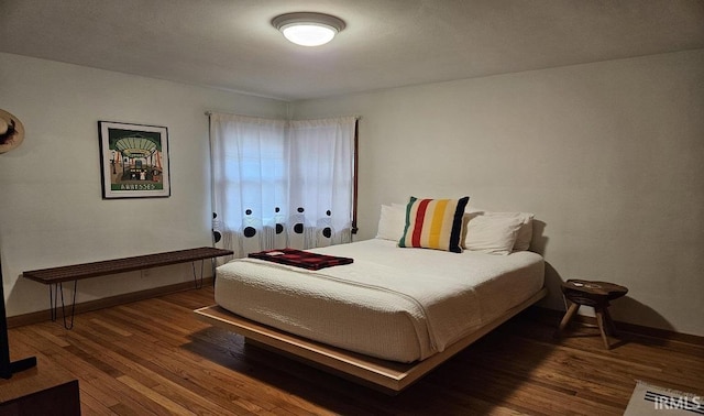 bedroom with baseboards and wood finished floors