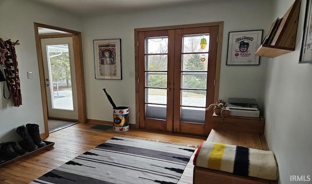 doorway to outside featuring light wood-type flooring, baseboards, and french doors