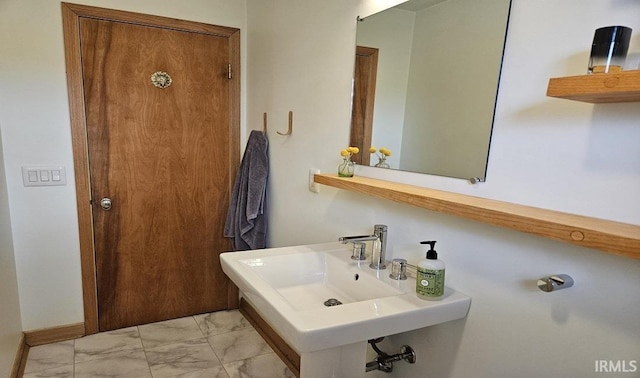 bathroom featuring marble finish floor and a sink