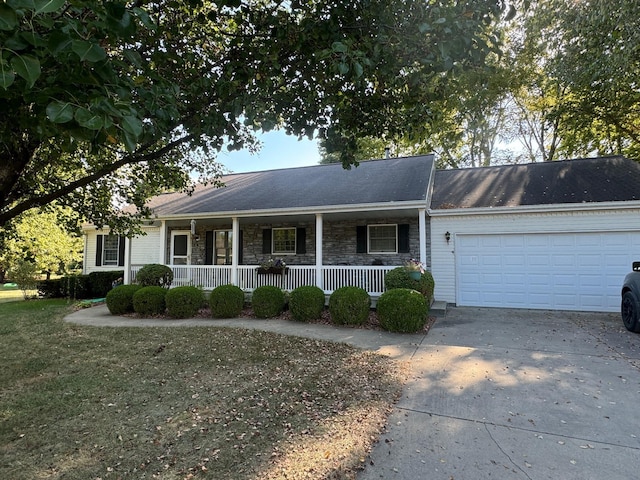 ranch-style home with driveway, an attached garage, covered porch, and stone siding