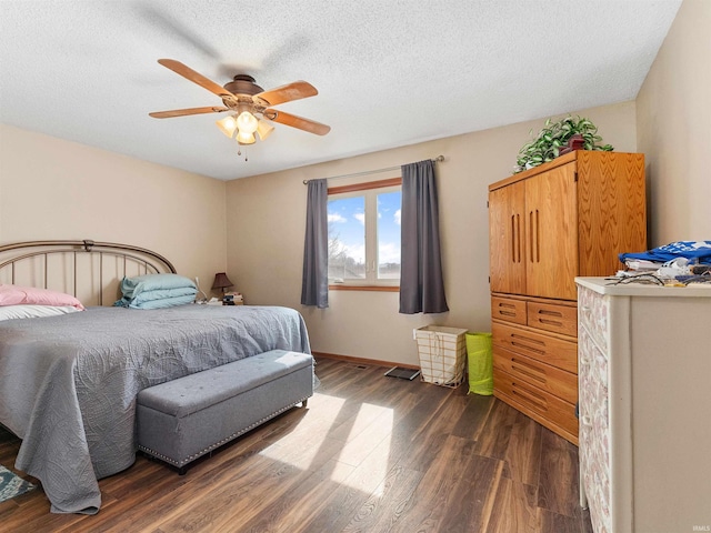 bedroom featuring dark wood-style floors, a textured ceiling, a ceiling fan, and baseboards