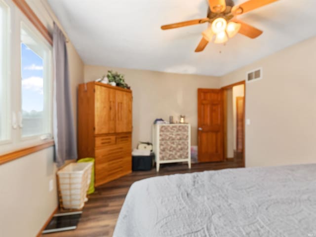 bedroom with dark wood-style flooring, visible vents, and a ceiling fan