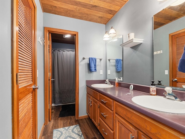 bathroom with wooden ceiling, double vanity, a sink, and wood finished floors