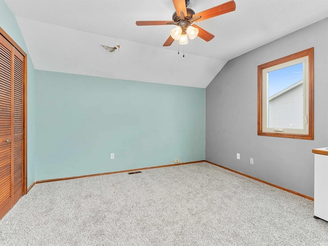 additional living space with lofted ceiling, carpet flooring, a ceiling fan, visible vents, and baseboards