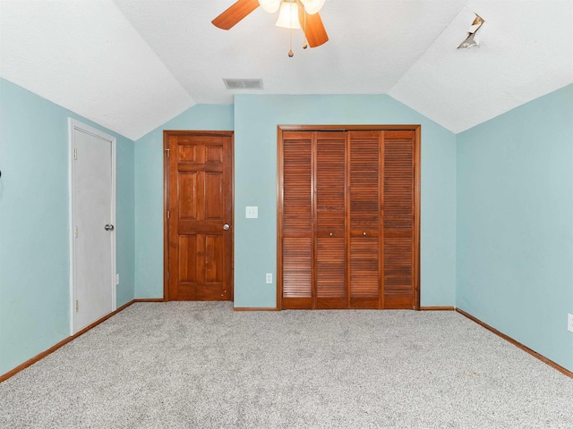 unfurnished bedroom featuring lofted ceiling, a closet, visible vents, and baseboards