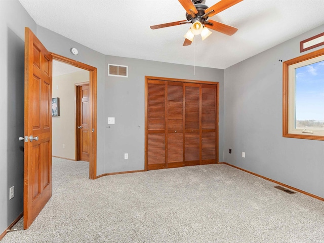 unfurnished bedroom with a closet, carpet, visible vents, and baseboards