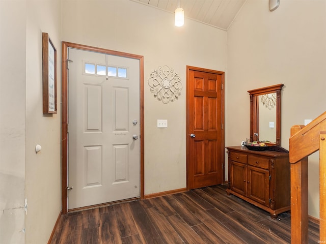 foyer entrance with vaulted ceiling, dark wood finished floors, and baseboards