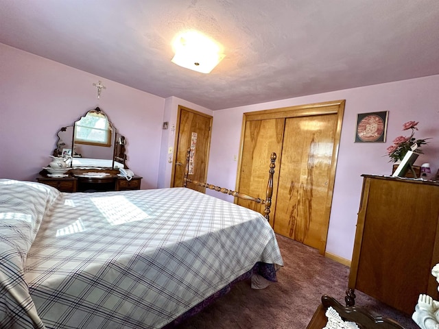 carpeted bedroom with a closet and baseboards