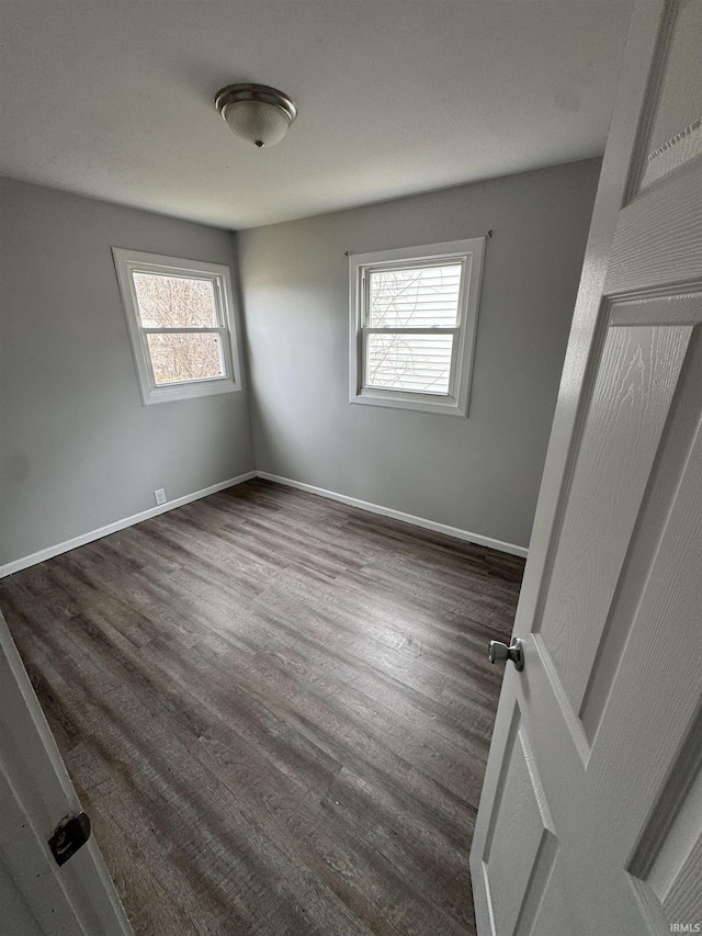 unfurnished bedroom featuring dark wood-style floors and baseboards