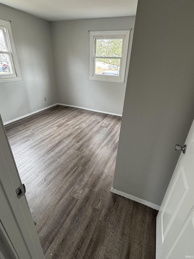 unfurnished room featuring dark wood finished floors and baseboards