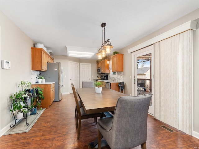 dining space featuring visible vents, baseboards, and wood finished floors