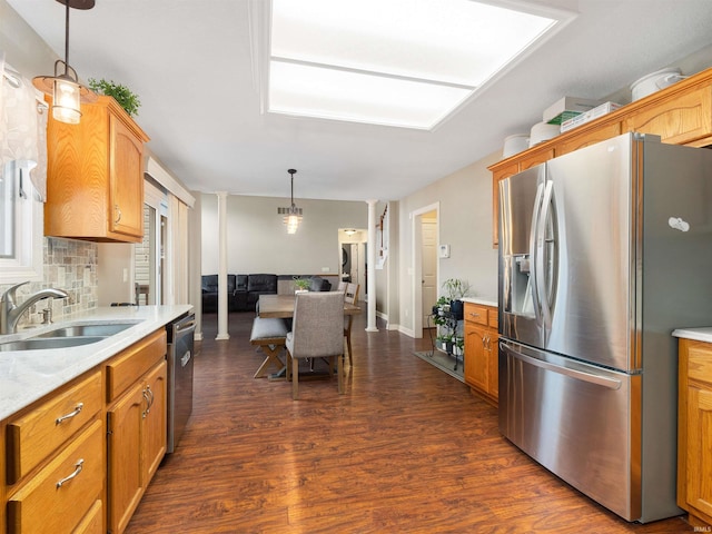 kitchen featuring decorative columns, decorative backsplash, dark wood-style floors, stainless steel appliances, and a sink