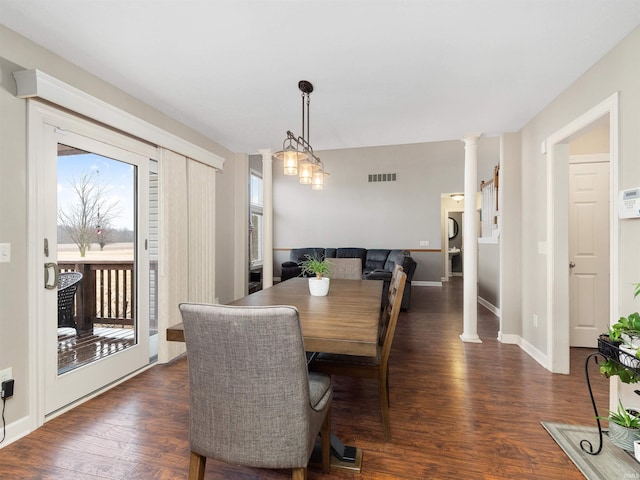 dining space featuring dark wood-style floors, baseboards, visible vents, and ornate columns