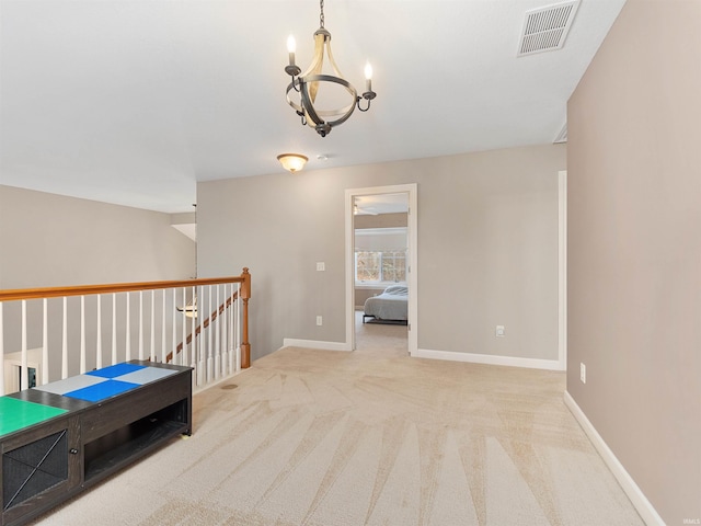 hallway with baseboards, visible vents, an upstairs landing, carpet floors, and a chandelier