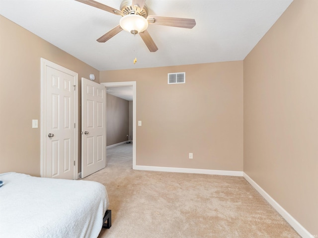 bedroom with light carpet, a ceiling fan, visible vents, and baseboards