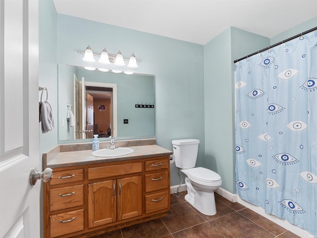 bathroom featuring a shower with curtain, toilet, vanity, tile patterned flooring, and baseboards