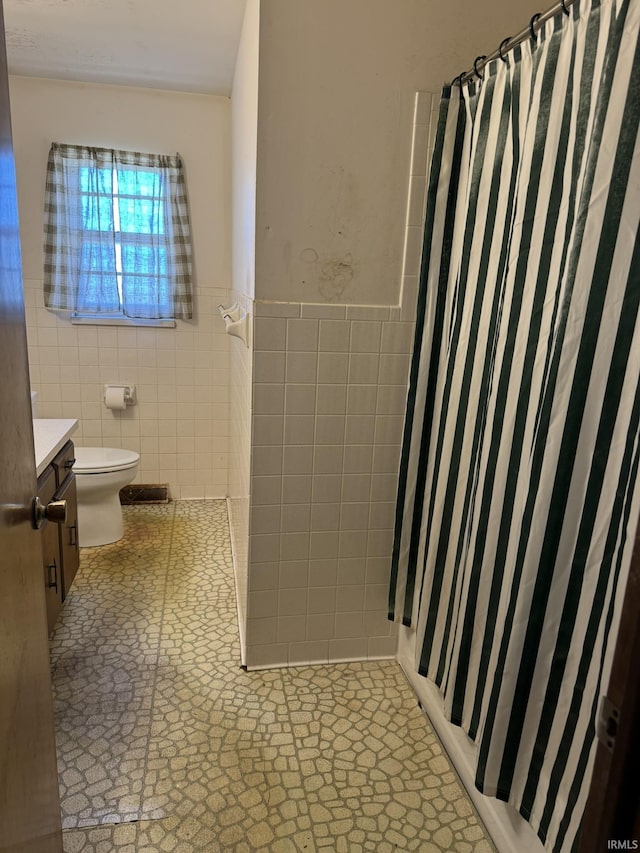 full bath featuring toilet, tile walls, and a shower with curtain