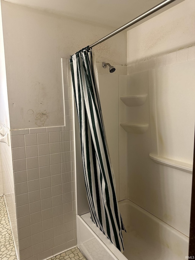 full bathroom featuring shower / tub combo with curtain and tile walls