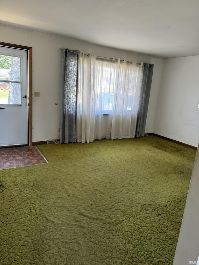 interior space featuring visible vents, baseboards, and carpet flooring