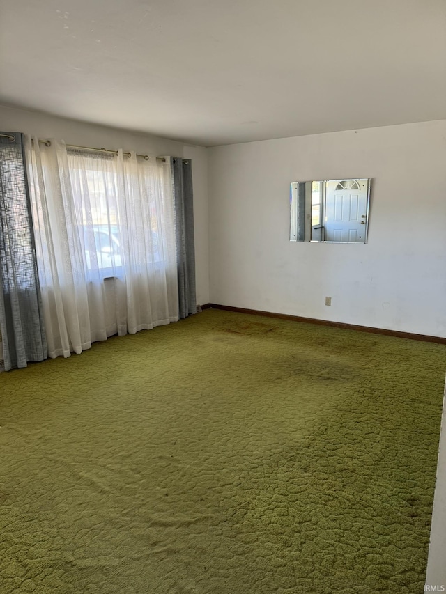 carpeted empty room with baseboards