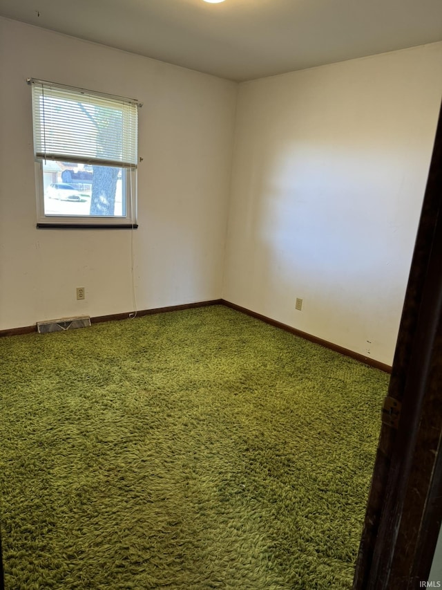 carpeted empty room with visible vents and baseboards