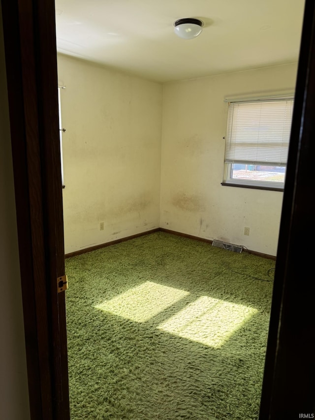 unfurnished room featuring carpet floors, visible vents, and baseboards