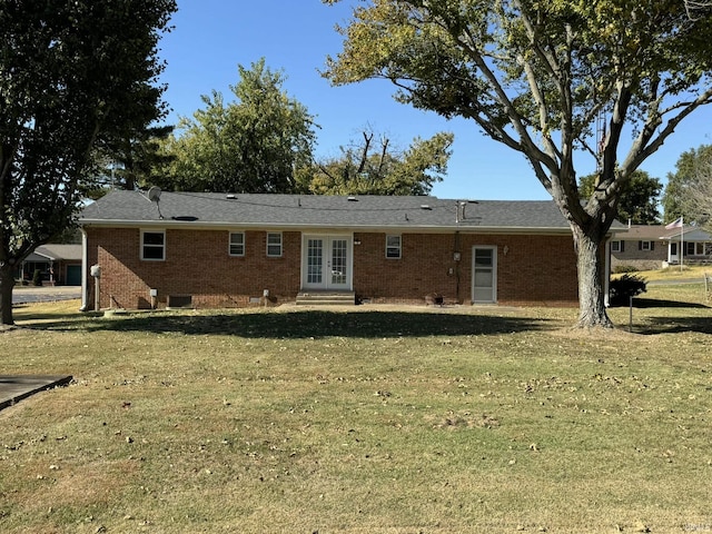 rear view of house featuring central air condition unit, brick siding, a yard, and french doors