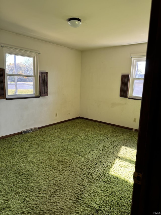 carpeted empty room featuring visible vents and baseboards