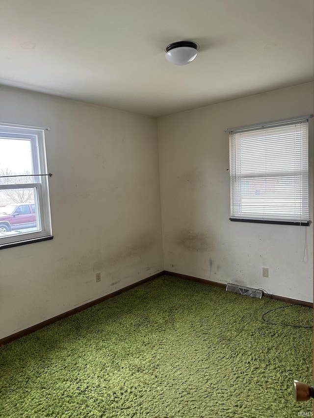 carpeted empty room with visible vents and baseboards