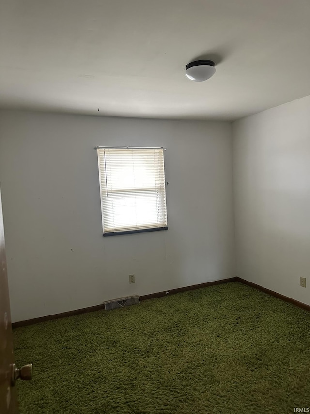 empty room featuring carpet flooring, visible vents, and baseboards