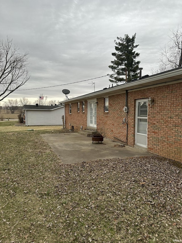 rear view of house featuring entry steps, french doors, a patio area, and brick siding