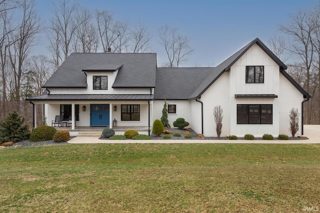 modern farmhouse style home featuring metal roof, a porch, a standing seam roof, and a front lawn