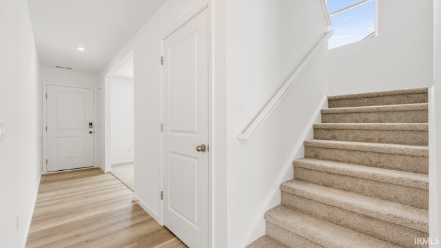 stairway with recessed lighting, baseboards, and wood finished floors