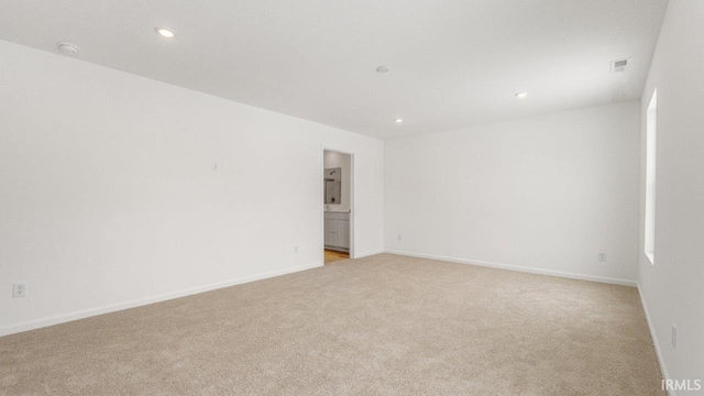 unfurnished room featuring baseboards, recessed lighting, visible vents, and light colored carpet