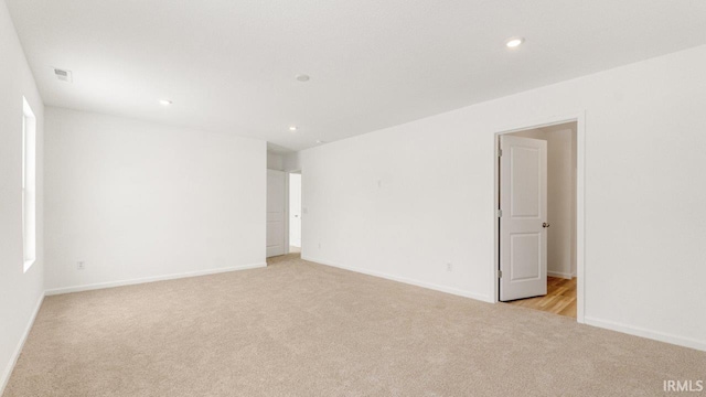 unfurnished room featuring light carpet, baseboards, visible vents, and recessed lighting