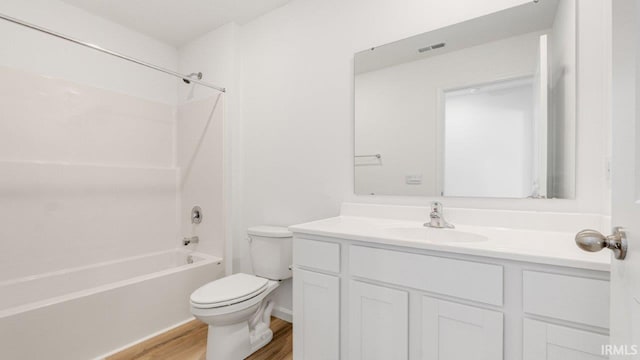 bathroom featuring visible vents, toilet, wood finished floors, vanity, and shower / bathing tub combination