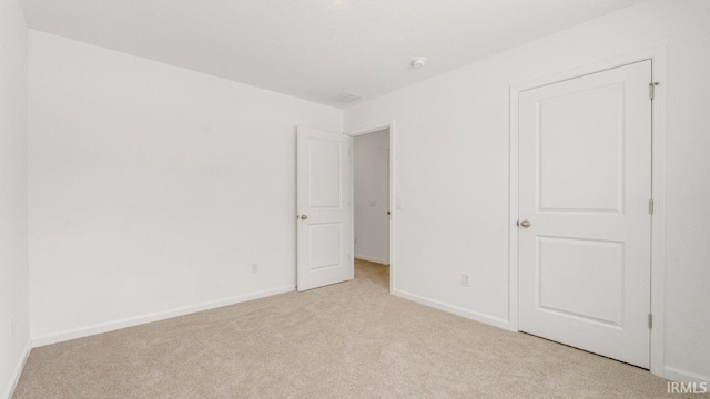 unfurnished bedroom featuring light carpet and baseboards