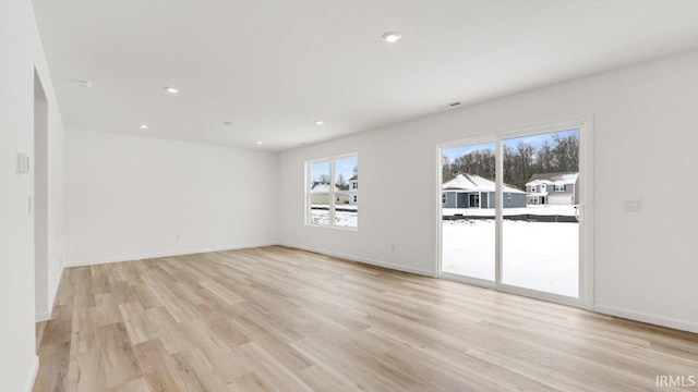 spare room with recessed lighting, light wood-style flooring, and baseboards