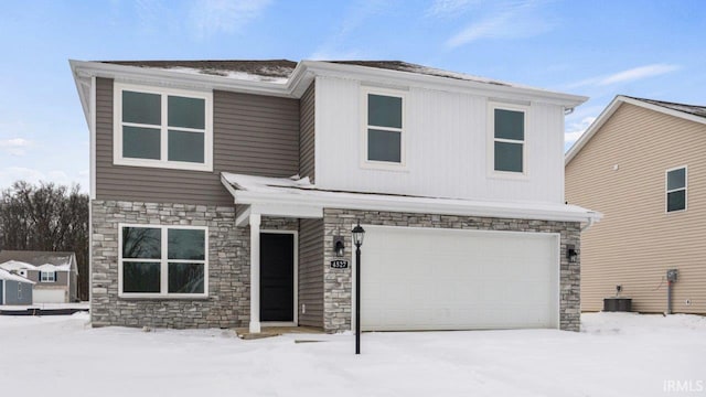 view of front of house featuring central AC unit and an attached garage