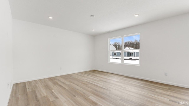 spare room with light wood-style flooring, baseboards, and recessed lighting