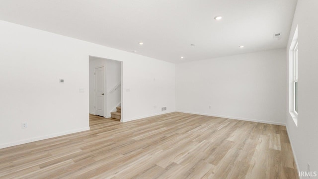 unfurnished room featuring stairs, baseboards, light wood-style flooring, and recessed lighting