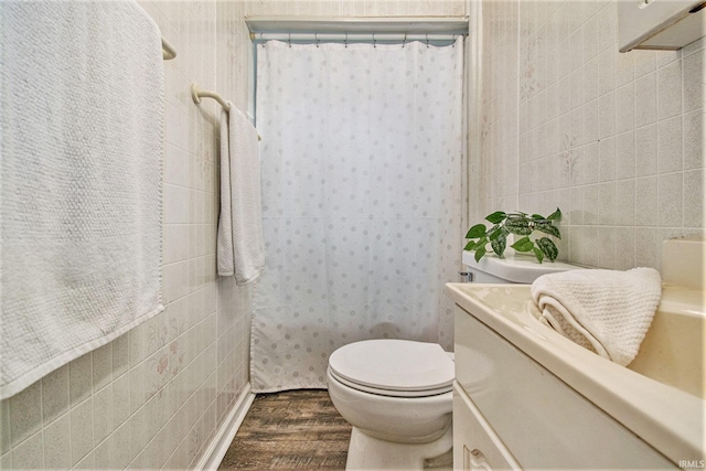 full bathroom featuring toilet, a shower with shower curtain, wood finished floors, vanity, and tile walls